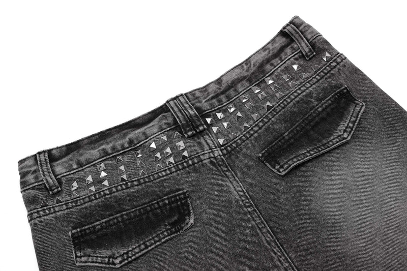Back waistband close-up of black denim with rows of silver pyramid studs