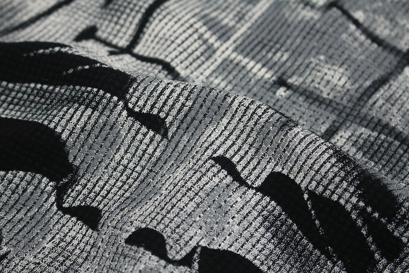 Close-up of distressed black and gray skeleton graphic tee fabric with textured cyber-grunge print