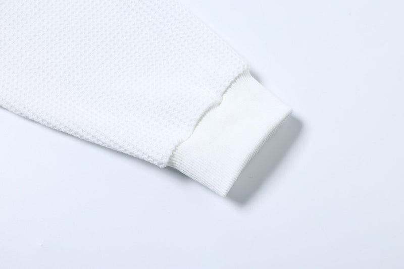 Close-up of white long sleeve cuff with ribbed trim and waffle knit sleeve