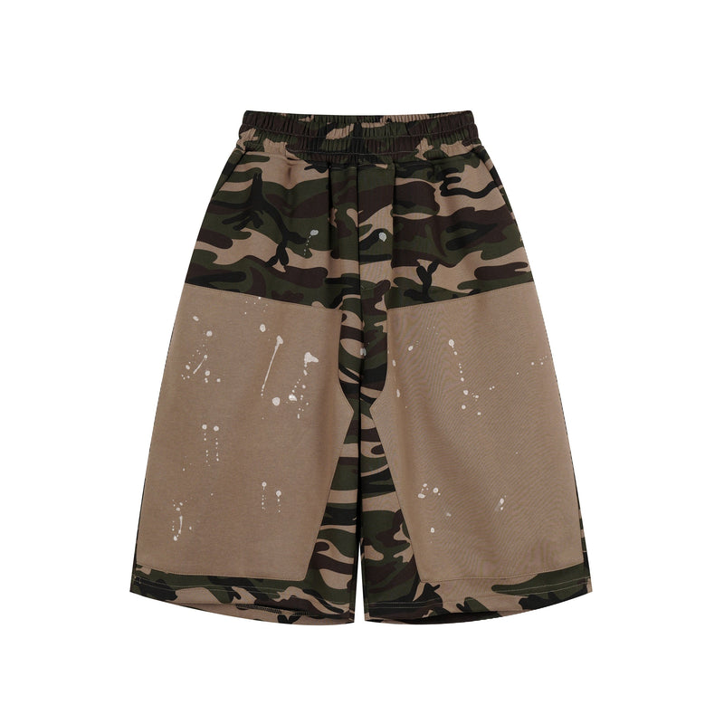 Front view of camo patchwork baggy shorts with tan panels and white paint splatter
