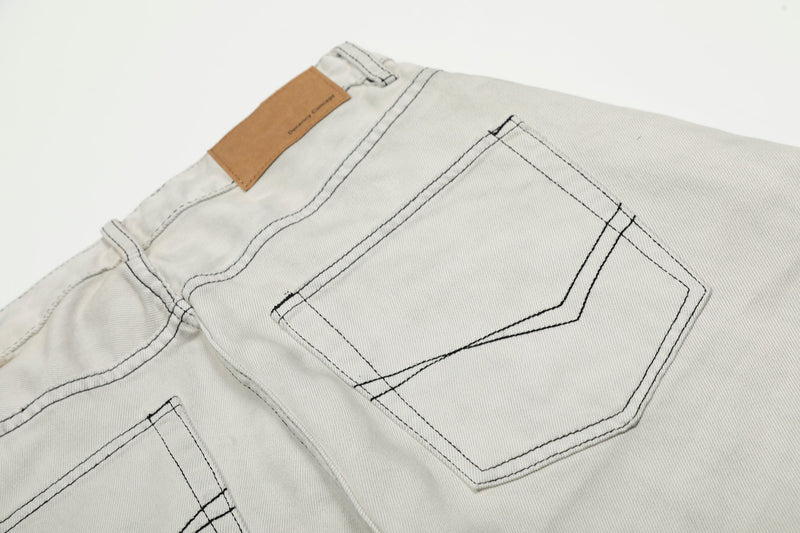 Close-up of back pocket and tan patch on light gray jeans with contrast stitching