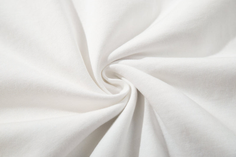 Close-up of soft white fabric with a smooth swirl texture, featuring the Seakoff mixed signals collage graphic tee design background