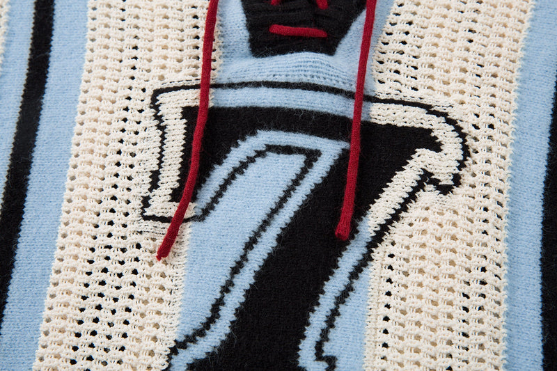Close-up of front number 7 graphic with red lace ties on light blue knit sweater