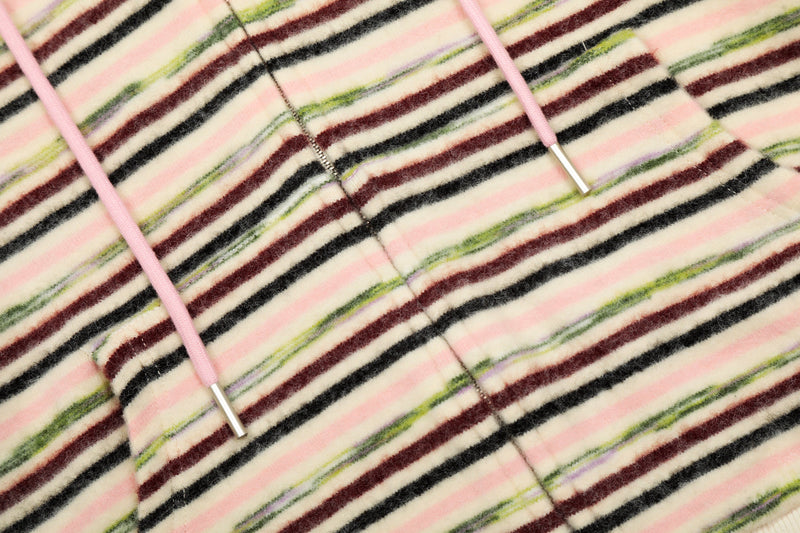 Close-up of fuzzy striped knit fabric with pink drawstrings and center zipper