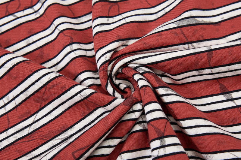 Red streetwear cotton T-shirt fabric with white and black graffiti-style stripes, twisted in a close-up texture shot