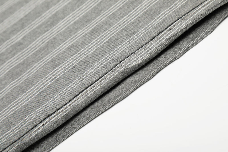Close-up of gray striped tee fabric and side seam with fine white stripe pattern
