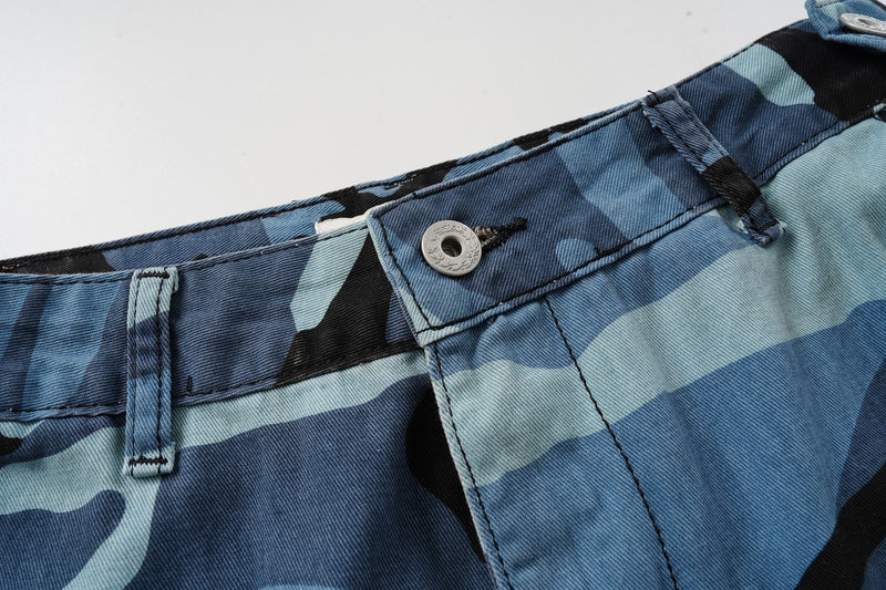Close-up of front waistband button and belt loop on blue camo cargo shorts