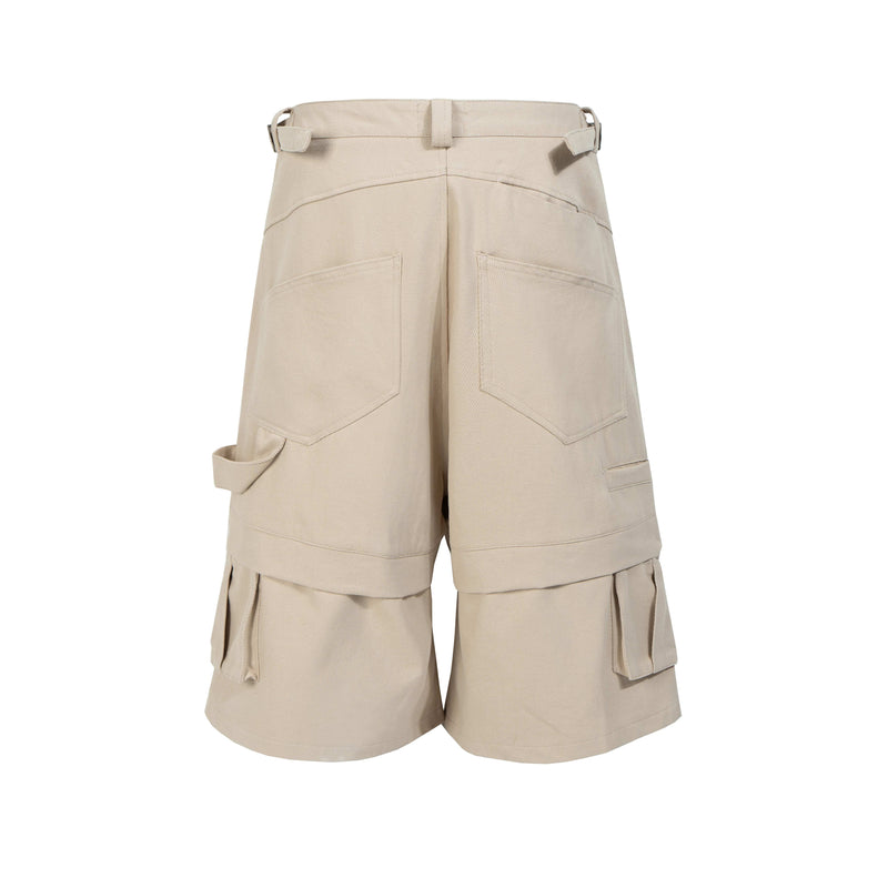 Beige layered cargo shorts with large side pockets and flap details, front view