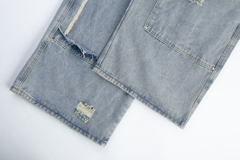 Close-up of light blue denim hem and lower leg with frayed patch detail