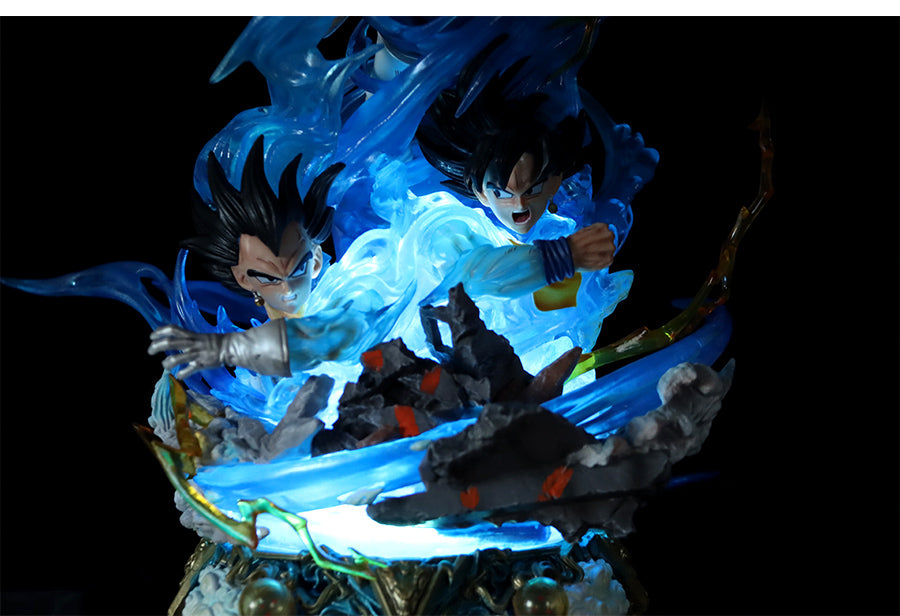 The Seakoff Goku Transformations Collectible Figure from Dragon Ball Super features two anime-style figures in dynamic poses with swirling blue energy, illuminated from below, on a rocky terrain base. This 46cm figure includes interchangeable heads for varied displays and glowing effects.