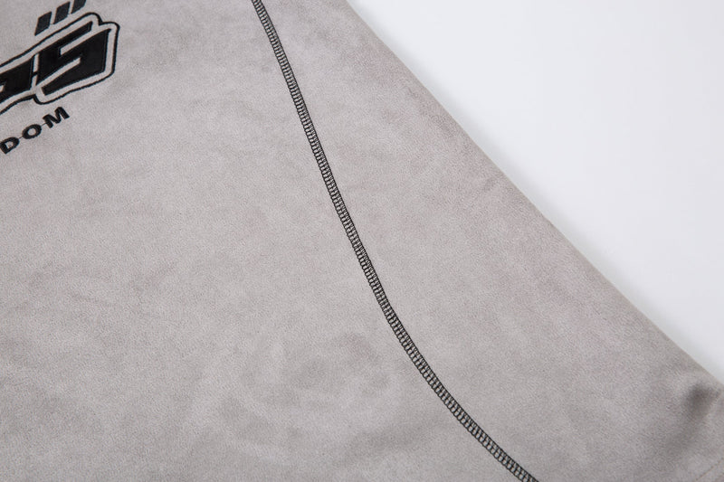Close-up of side seam and torso panel on the light gray polo shirt