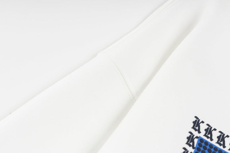 Close-up of white hoodie shoulder seam and sleeve with part of the chest graphic