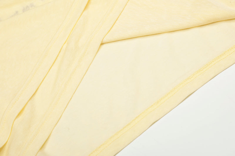 Close-up of light yellow side hem and sleeve fabric folds