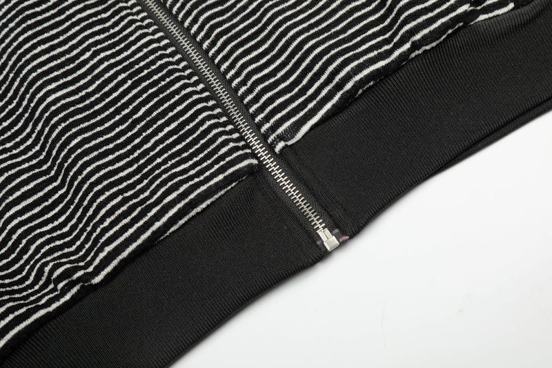 Close-up of black striped hoodie hem and zipper bottom