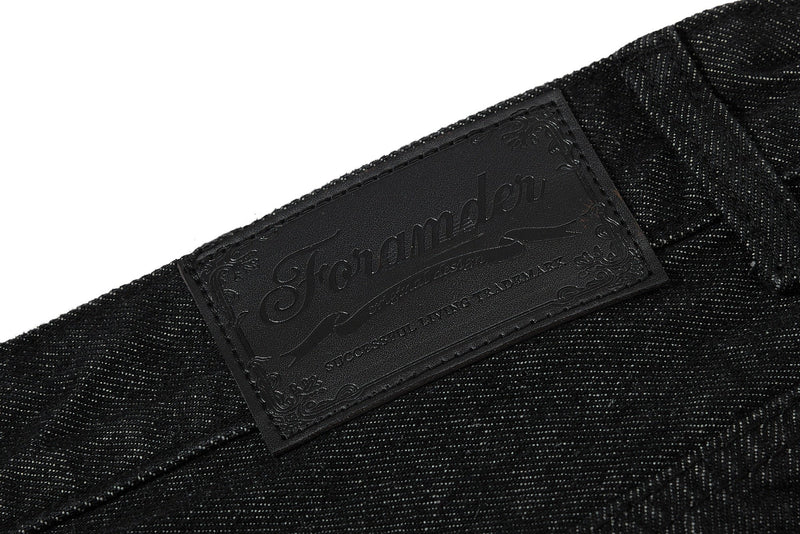 Close-up of black logo patch on the back waistband of denim shorts