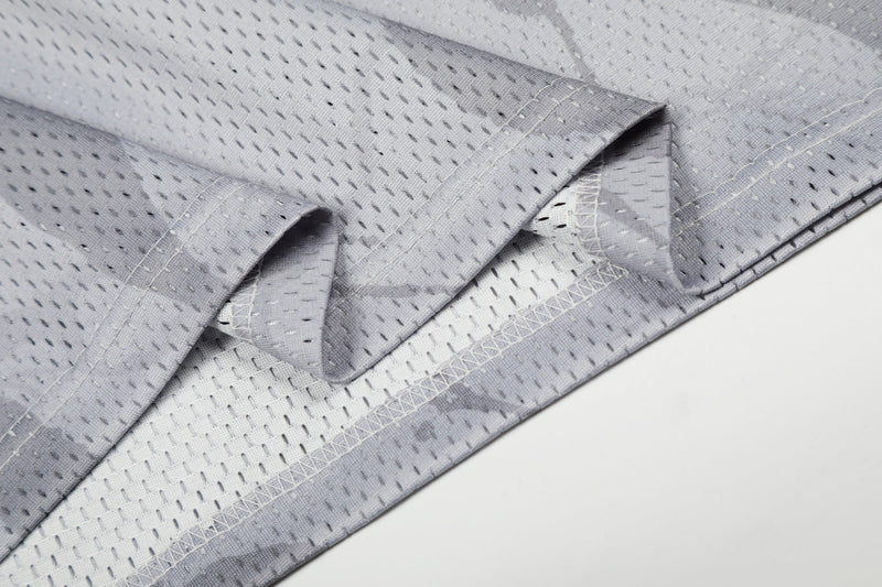 Close-up of a gray mesh football jersey hem with perforated fabric and visible stitched seams
