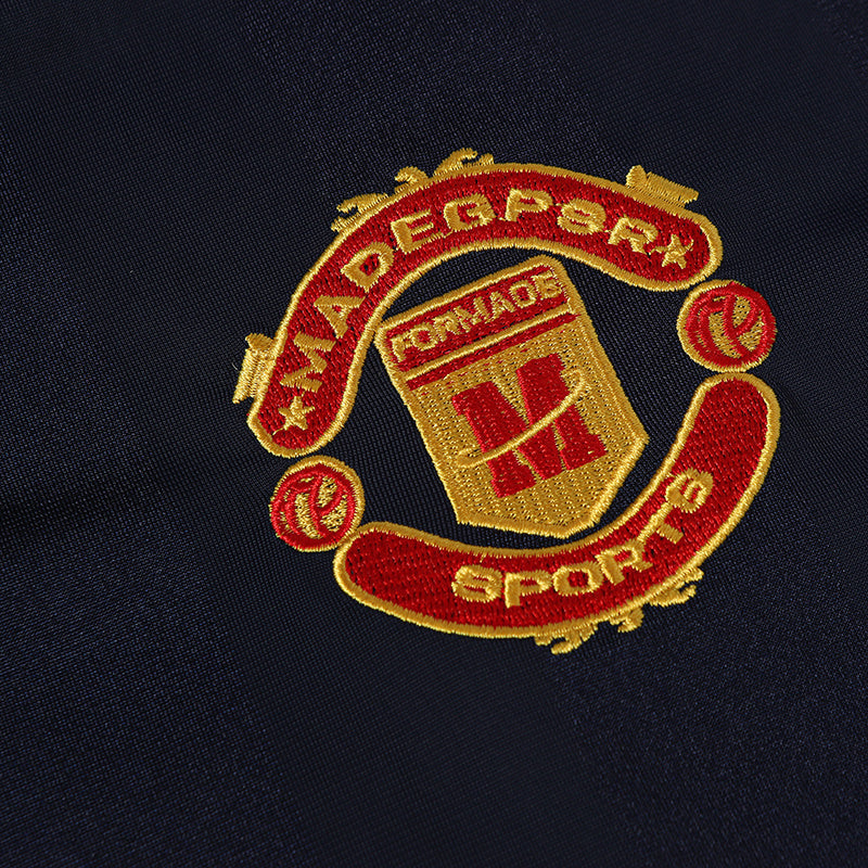 Embroidered red and gold sports club crest on navy performance soccer jersey