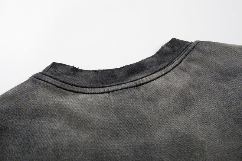 Washed black graphic T-shirt with raw edge crew neckline and faded vintage punk zine style finish