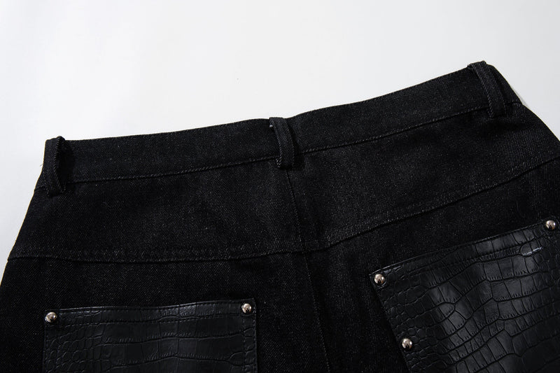 Close-up of back waistband on black wide-leg denim pants with crocodile-textured pocket panels