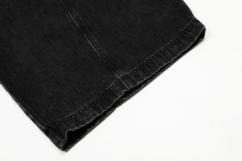 Close-up of the hem on washed black denim pants with stitched cuff detail