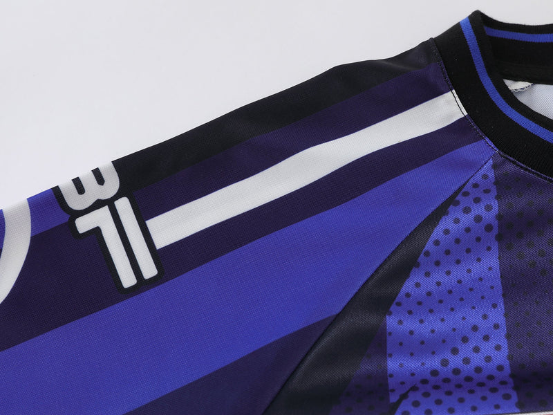 Close-up of blue jersey shoulder and sleeve with striped print and black ribbed neckline