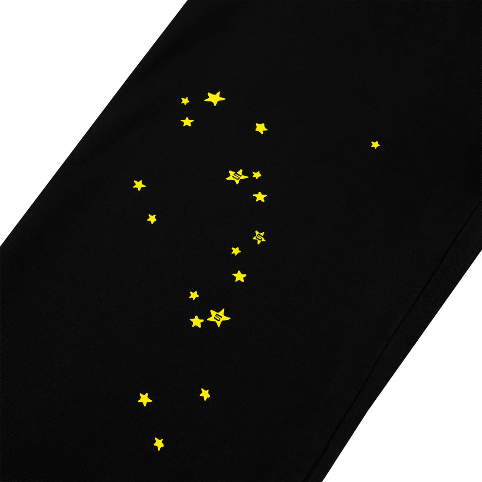 The Sp5der Sweatpants – Unisex Black Cotton Sweatpants with Flame Side Logo and Star Print capture bold streetwear style with bright yellow stars, perfect for those who love standout joggers.