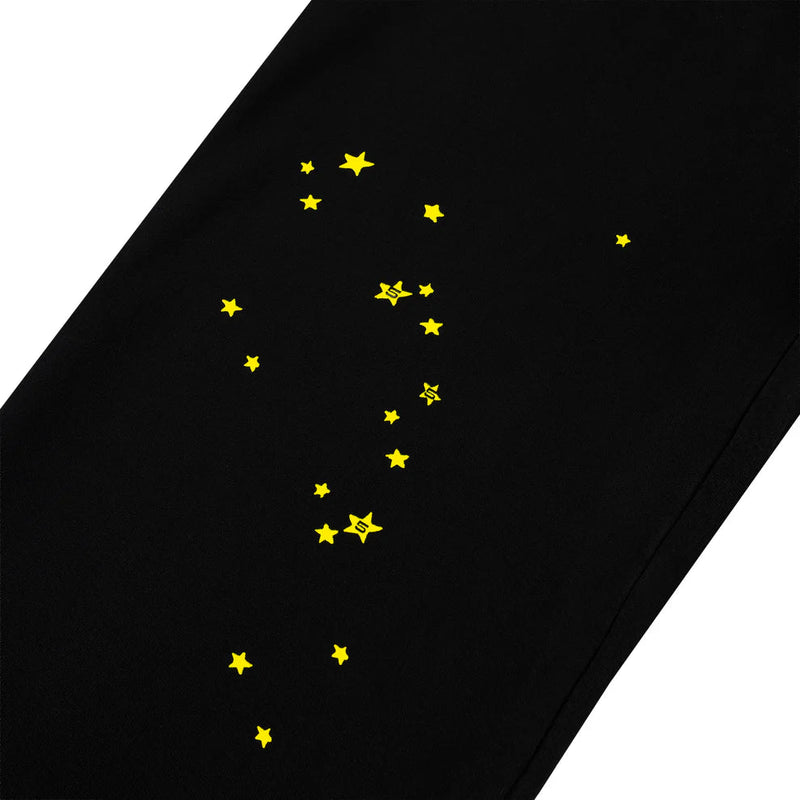The Sp5der Sweatpants – Unisex Black Cotton Sweatpants with Flame Side Logo and Star Print capture bold streetwear style with bright yellow stars, perfect for those who love standout joggers.