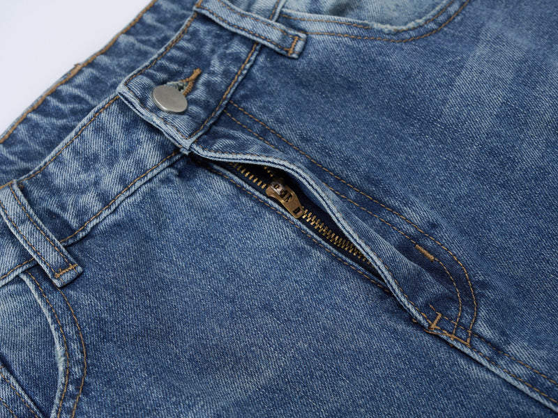 Close-up of front fly with zipper and snap on faded blue denim jeans