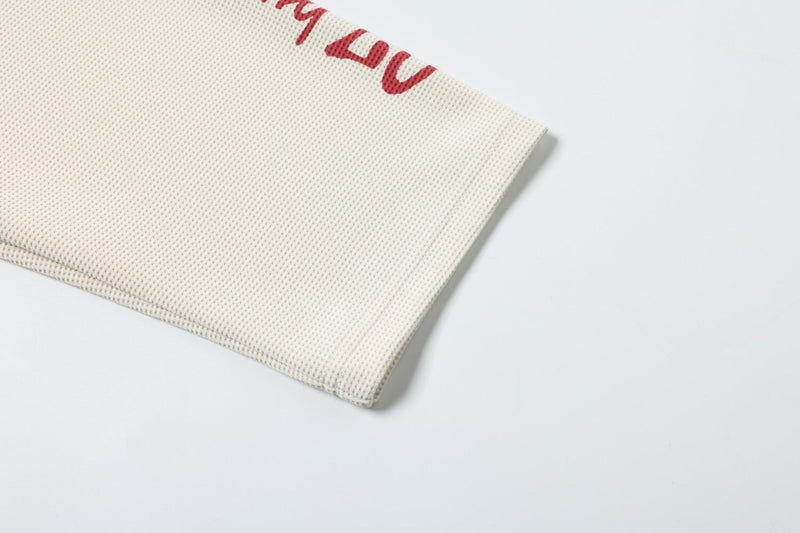 Lower sleeve hem detail on cream textured long sleeve tee