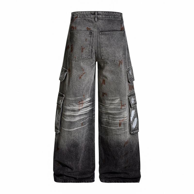 Back view of gray wide-leg cargo jeans with rear pockets and faded paint splatter