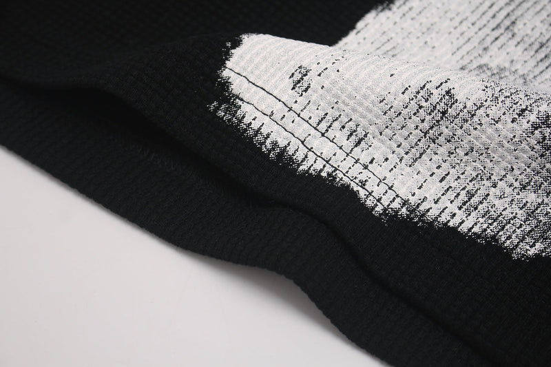 Close-up of black oversized tee with distressed white gothic cross graphic on soft ribbed fabric