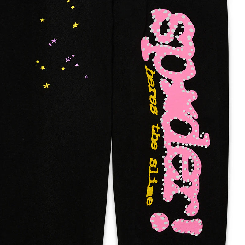 Sp5der Sweatpants – Unisex black cotton sweatpants with a bold pink Sp5der! graphic logo, “beware the slime” in yellow, and pink and yellow star prints for added flair.