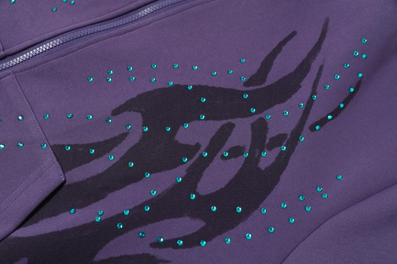 Close-up of purple hoodie front graphic with teal rhinestones and black flame design