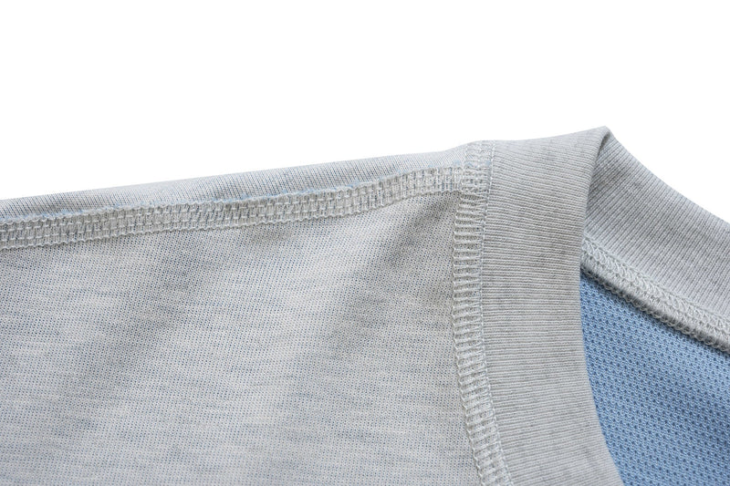 Close-up of a light gray varsity graphic tee collar and stitching with blue inner fabric detailing