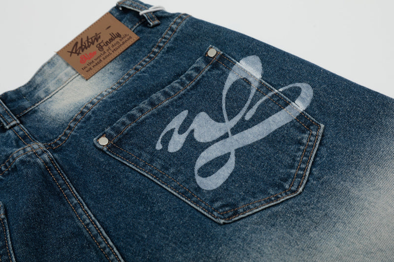 Back pocket of blue bleached denim shorts with printed logo graphic and contrast stitching