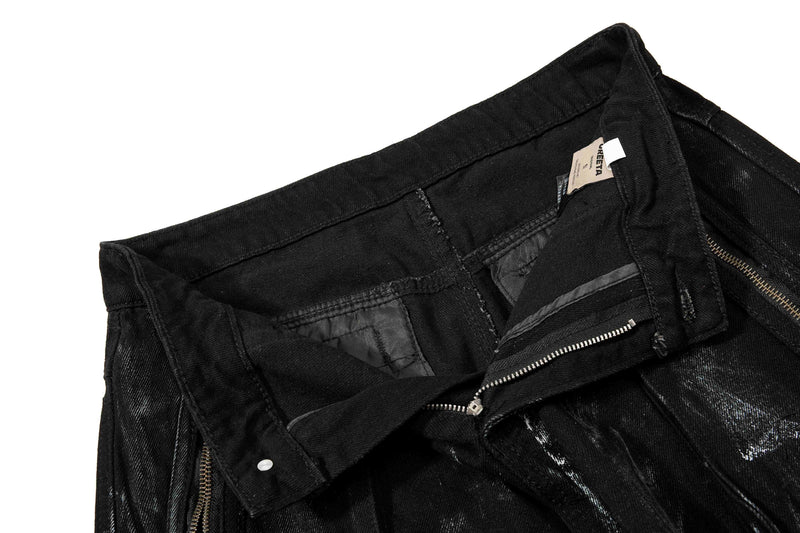 Inside waistband close-up showing lining, zipper, and care label on black denim