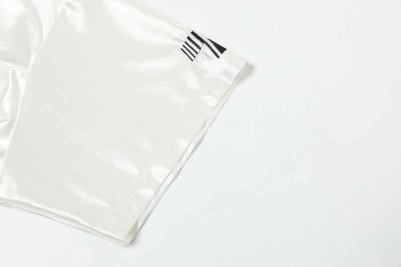 White mesh varsity jersey sleeve with black striped detail on a football-inspired graphic tee