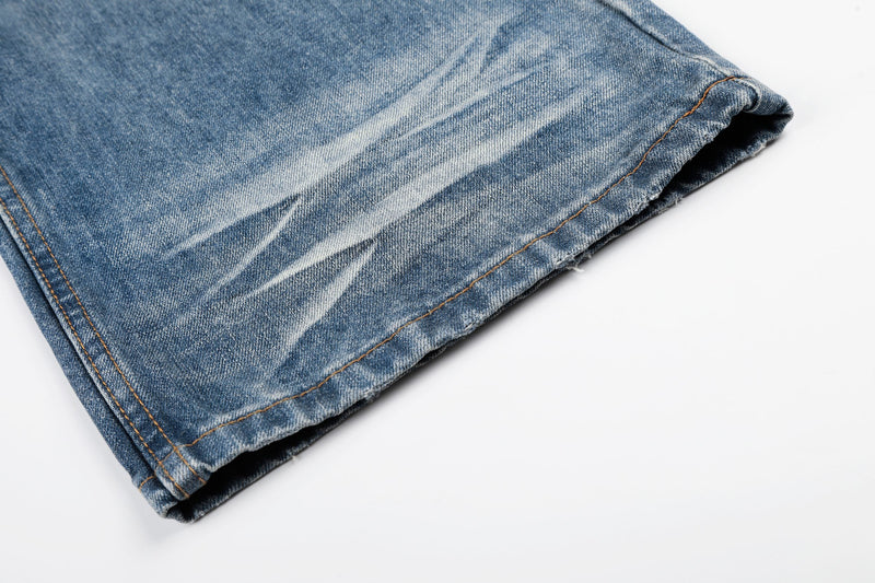 Close-up of hem on faded blue denim wide leg jeans