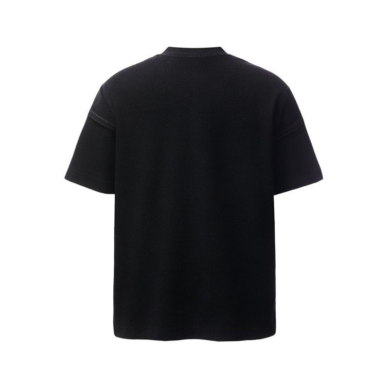 Black waffle knit T-shirt with a crew neck and relaxed short sleeves, shown from the back on a white background