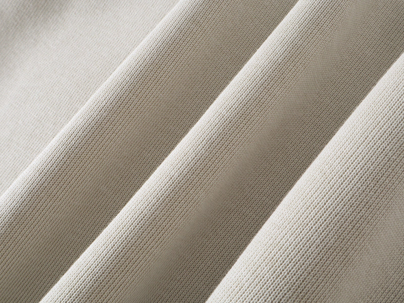 Close-up of beige hoodie fabric texture with diagonal sleeve folds