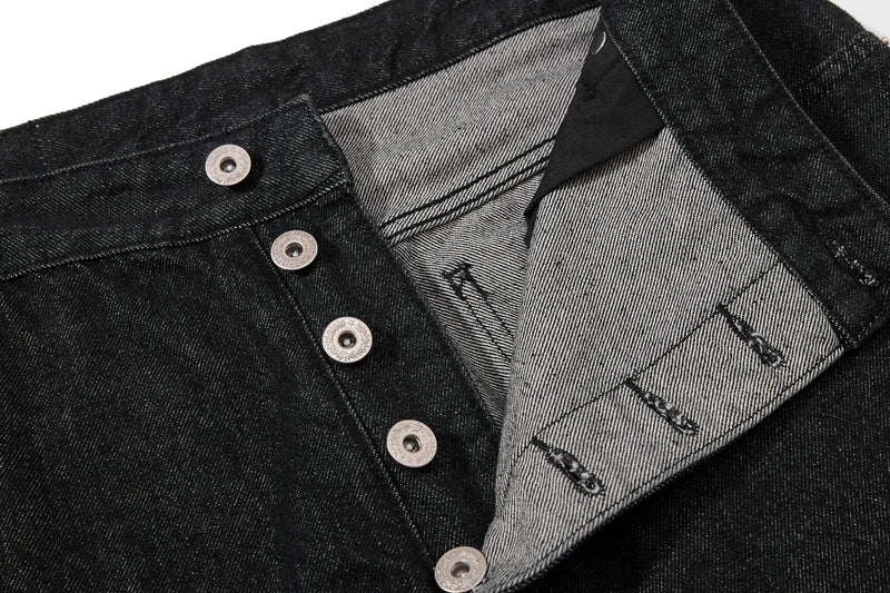 Close-up of the waistband and open front showing light striped inside denim