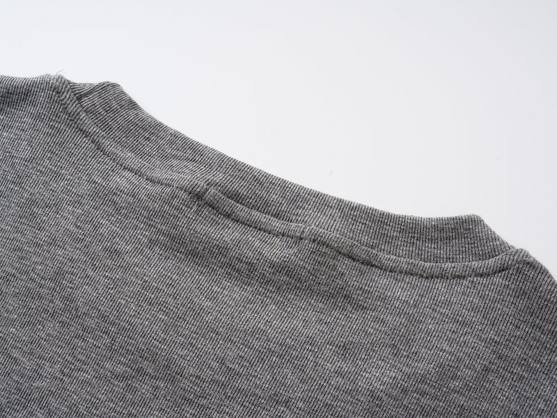 Close-up of gray tee collar showing ribbed crew neck and shoulder seam