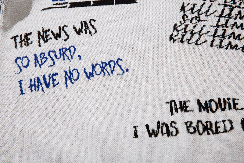 Close-up of handwritten black and blue text embroidery on white knit sweater back