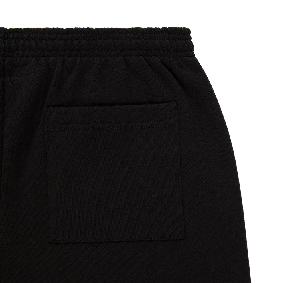 Close-up of Sp5der Sweatpants – Unisex Black Cotton Sweatpants with Flame Front Logo Print, featuring an elastic waistband and a single square hip pocket—a streetwear staple.
