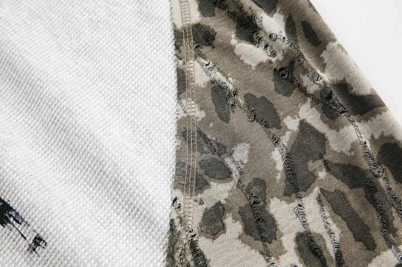 Close-up of side seam where white waffle-knit body meets camouflage sleeve fabric