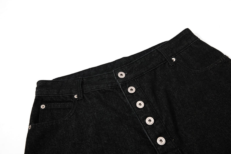 Close side view of black denim shorts showing the front button placket and waistband