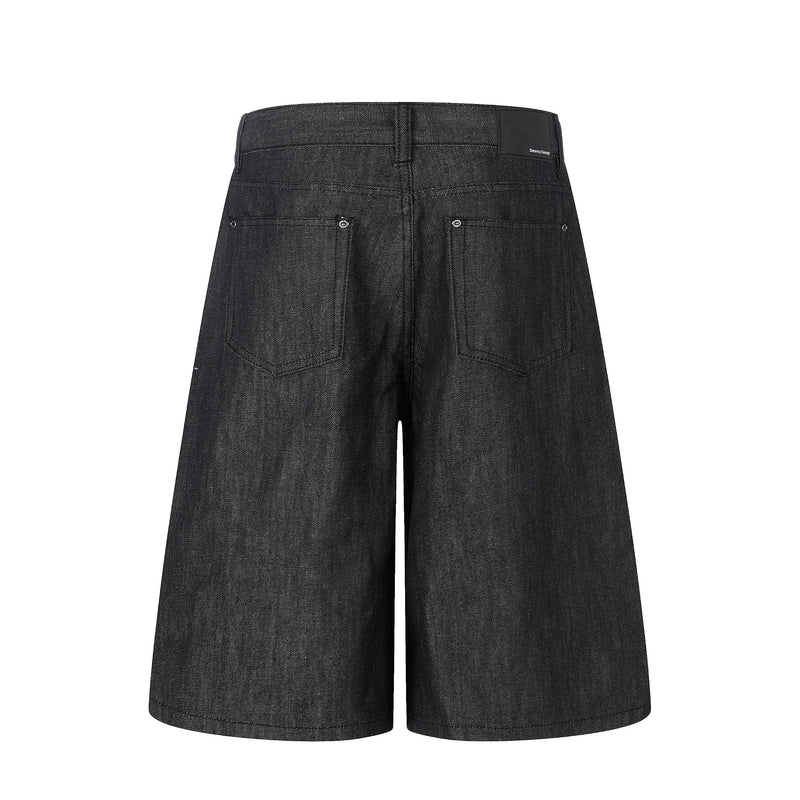 Back view of black raw denim baggy shorts with patch back pockets and logo waistband tab
