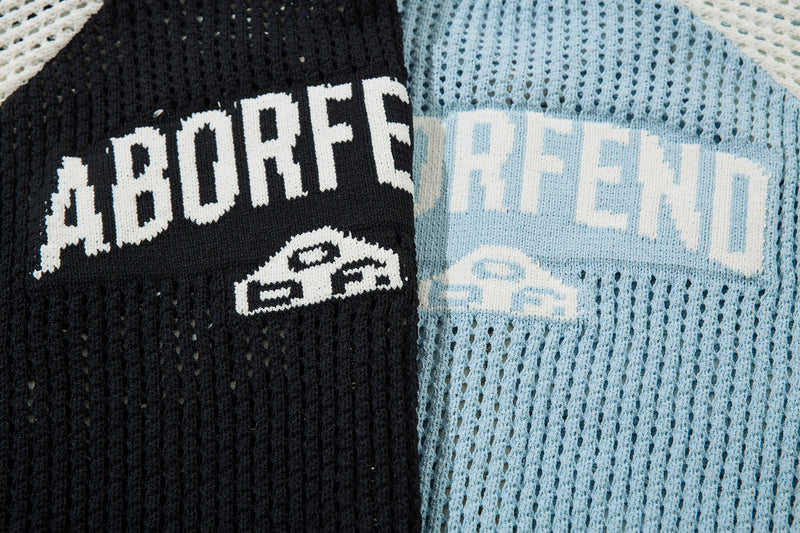 Close-up of black and light blue mesh knit jacket front lettering and chest logos