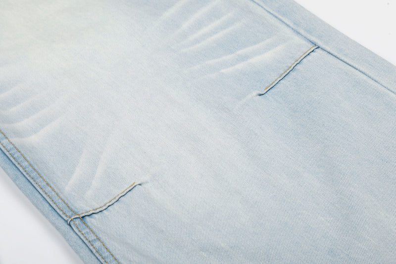 Close-up of light wash jean leg with side seam and hem stitching