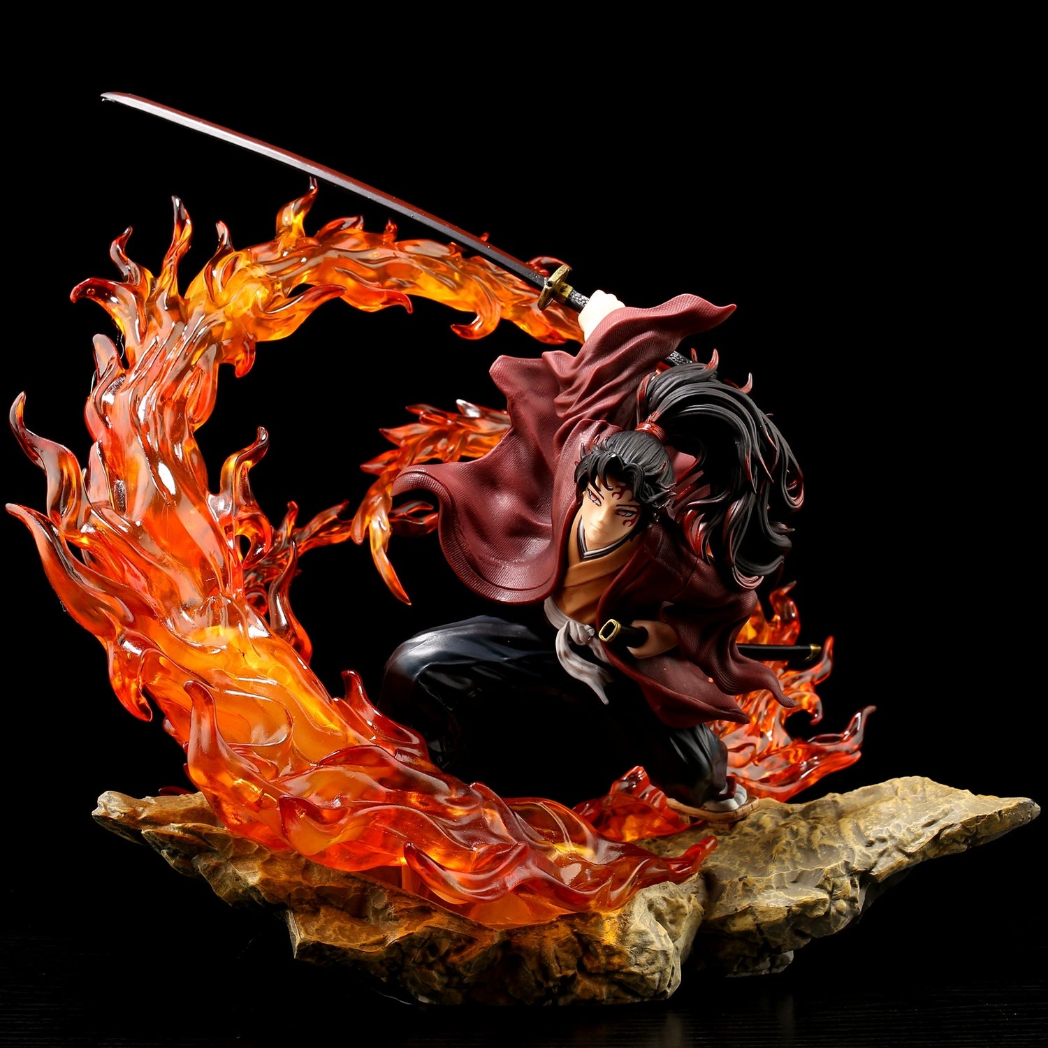 Explore the high-quality &quot;Tsugikuni Yoriichi Demon Slayer Figure,&quot; a 29cm premium PVC statue featuring dynamic flame effects. This prized collectible shows the character kneeling with a katana, embodying Breath of the Sun, dressed in a maroon top and dark pants on a rocky base against a black backdrop.